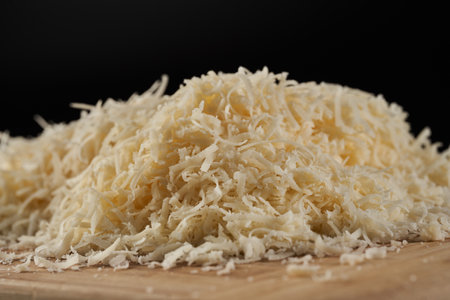 Parmesan block grated in detailed closeup over black backgroundの写真素材