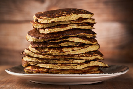 A pile of protein banana and oatmeal pancakes on a rustic wooden board
