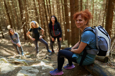 Group of women hikers with backpacks hiking on a trail in the mountainsの写真素材