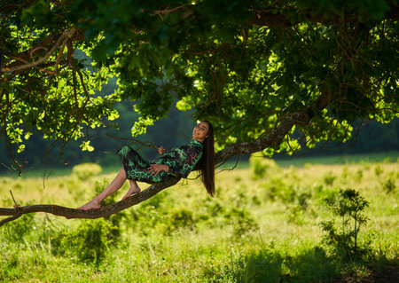Gorgeous Hispanic young woman beauty model in green dress in a forest with centennial oak treesの写真素材