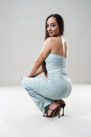 Beautfiful long hair brunette young woman posing isolated on gray background in various posturesの写真素材