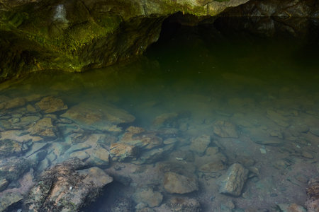 Karstic spring in a cave in the limestone mountains, feeding a river