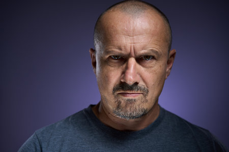 Authoritative man with a confrontational expression, displaying an unyielding attitude and a sharp...