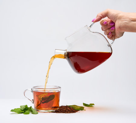 Closeup of a cup of South African Rooibos tea long cut, isolated on white background