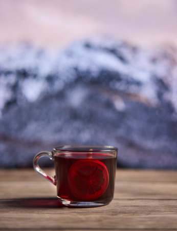 Mulled wine on a rustic board with snowy mountains in the backgroundの写真素材