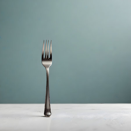 Fork on a white wooden table against a blue background with copy spaceの素材