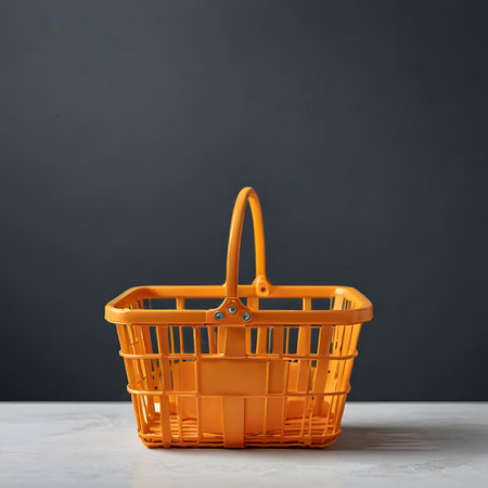 Empty orange shopping basket on a gray background. Copy space for text.の素材