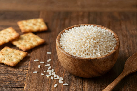 Rice in a wooden bowl and crackers on a wooden backgroundの素材