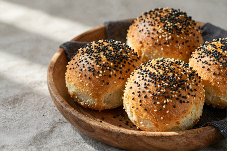 Buns with sesame seeds in a wooden plate on a gray backgroundの素材
