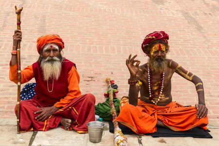 VARANASI, INDIA - JANUARY 03, 2020 : Two unidentified Hindu sadhu holy man, sits on the ghat near...