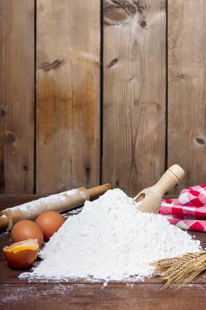 flour, spoon, eggs  and roller on wooden background - foodの写真素材