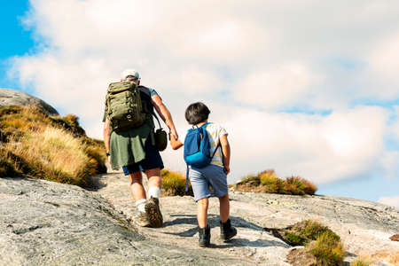 Rear View Of Father And Son Hiking In mountainの写真素材
