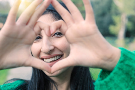 Close up image of smiling woman in swimwear making a heart shape with hands - Healthy lifestyle, self love and body care conceptの写真素材