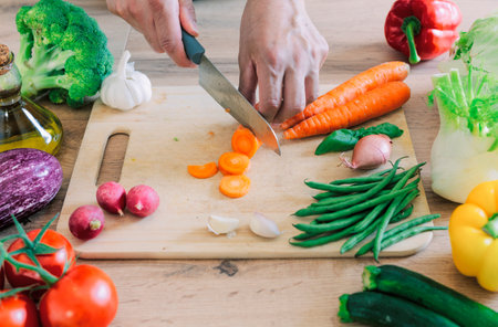 Hands cutting vegetables in the kitchenの写真素材