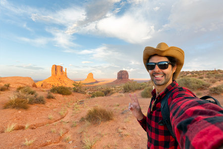 handsome tourist takes selfie photo in Monument Valley, meaning valley of the rocks, which is a...