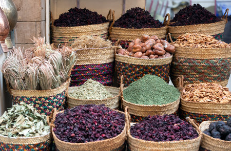 Various dried herbs, spices, and karkade tea are sold at the Egyptian street market. Goods in large wicker baskets and on shelves. The wall of the house with peeling whitewash is visible.の写真素材