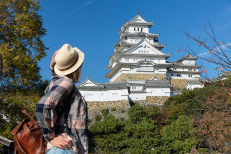 A woman in front of Himeji Castle in Himeji city in Japan in autumnの写真素材