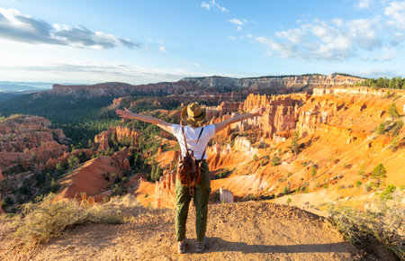 Girl relaxing on vacation hiking trip. Woman standing next to Thor's Hammer hoodoo on top of mountain looking at beautiful view. Bryce Canyon National Park, Utah, USAの写真素材