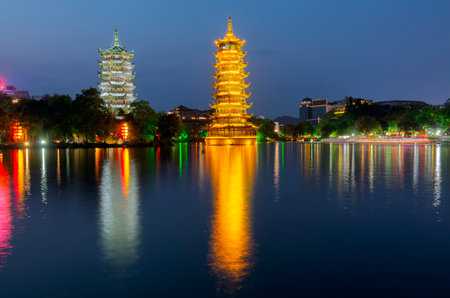 Night view of the Sun and Moon Twin Pagodas at Shanhu Lake (Fir Lake). Gold and Silver Pagodas illuminated at downtown of Guilin, China. Guilin is a popular tourist destination of Asia.の写真素材