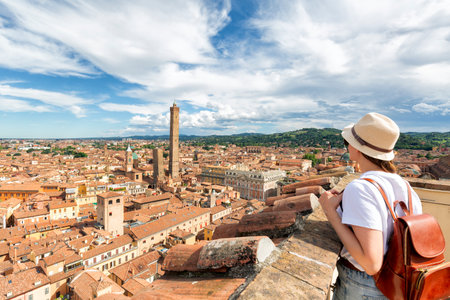 Beautiful happy traveler girl looking and enjoying visiting the historic city of Bologna, Italy.