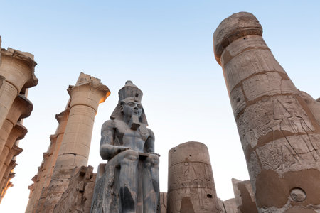 Seated statue of Ramesses II by the Luxor Temple entrance, sunset scenery, Egypt