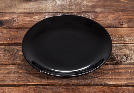 black plate on a dark wooden table of the boards.の写真素材