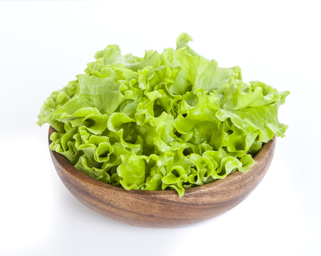 Fresh lettuce in a wooden bowl. Isolated on white backgroundの写真素材