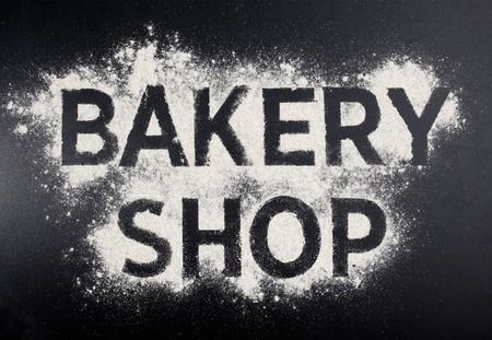 Bakery shop word made of flour on black table.の写真素材