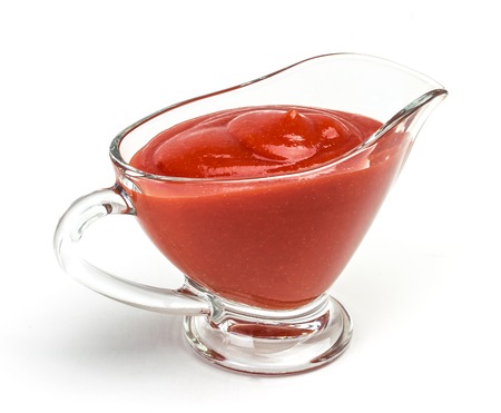 Closeup of tomato paste in glass bowl, isolated on white backgroundの写真素材