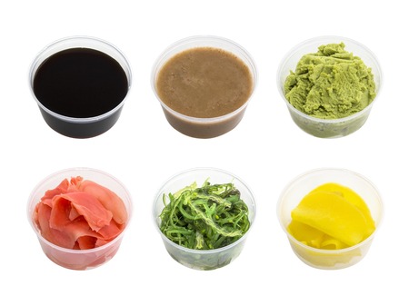 Soy sauce, wasabi, pickled ginger, Chuka, sesame sauce and pickled radishes in small bowl isolated on white backgroundの写真素材