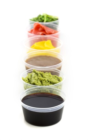 Soy sauce, wasabi, pickled ginger, Chuka, sesame sauce and pickled radishes in small bowl isolated on white backgroundの写真素材