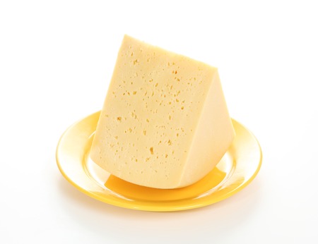 Gouda cheese on a yellow plate isolated on white backgroundの写真素材