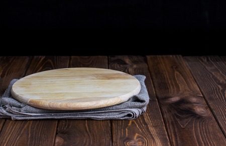 Round cutting board on dark wooden table