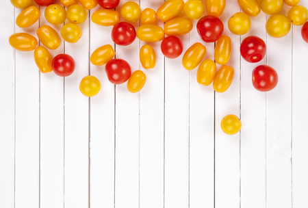 Colorful cherry tomatoes on wooden table background. Top view with copy space.の写真素材
