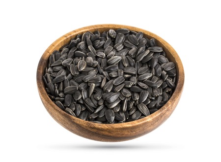 Black sunflower seeds in dish, isolated on white background with clipping pathの写真素材
