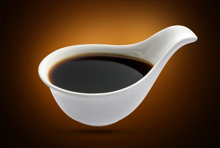Bowl with soy sauce isolated on black backgroundの写真素材