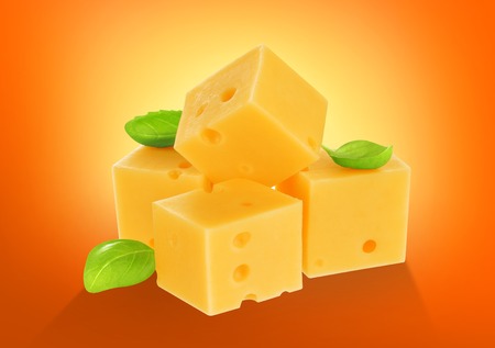 Piece of cheese with basil leaves isolatedの写真素材