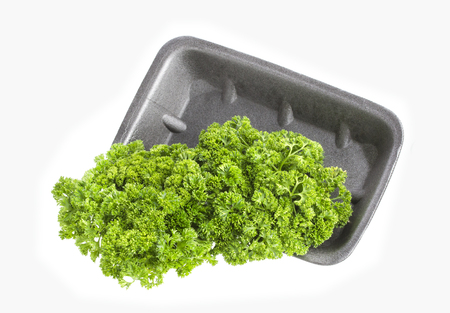 Parsley in plastic wrap packaging isolated on white backgroundの写真素材