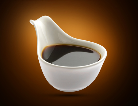 Bowl with soy sauce isolated on black backgroundの写真素材