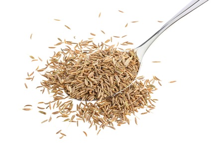 Cumin seeds or caraway in spoon isolated on white background, top viewの写真素材
