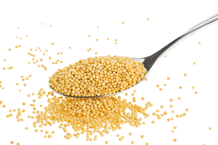 Pile of mustard seeds isolated on white backgroundの写真素材