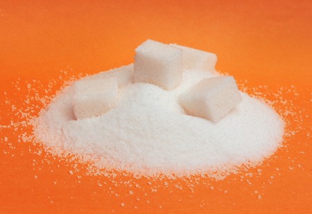 Close-up of pile of sugar isolated on blue backgroundの写真素材