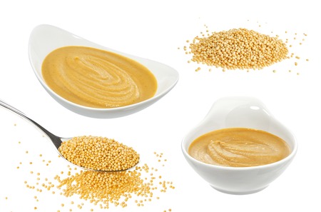 Mustard in bowl isolated on white background. Seeds of yellow mustardの写真素材