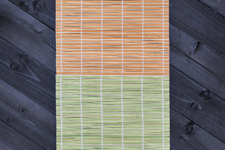 Bamboo mat on dark wooden table, top viewの写真素材