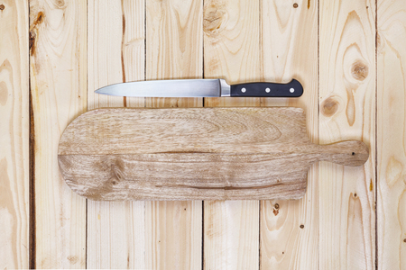 Chopping board with a knife on a wooden table. top viewの写真素材