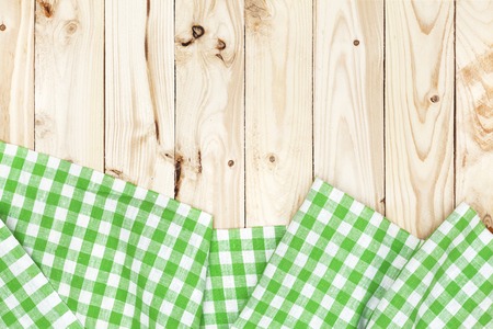 Green checkered tablecloth on a light wooden table, top viewの写真素材