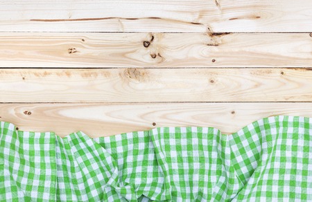 Green checkered tablecloth on a light wooden table, top viewの写真素材