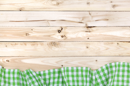 Green checkered tablecloth on a light wooden table, top viewの写真素材
