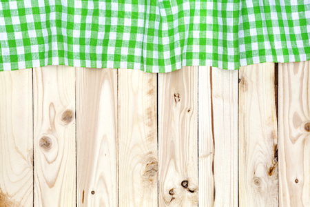 Green checkered tablecloth on a light wooden table, top viewの写真素材