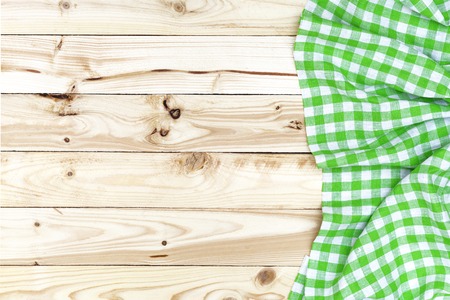 Green checkered tablecloth on a light wooden table, top viewの写真素材